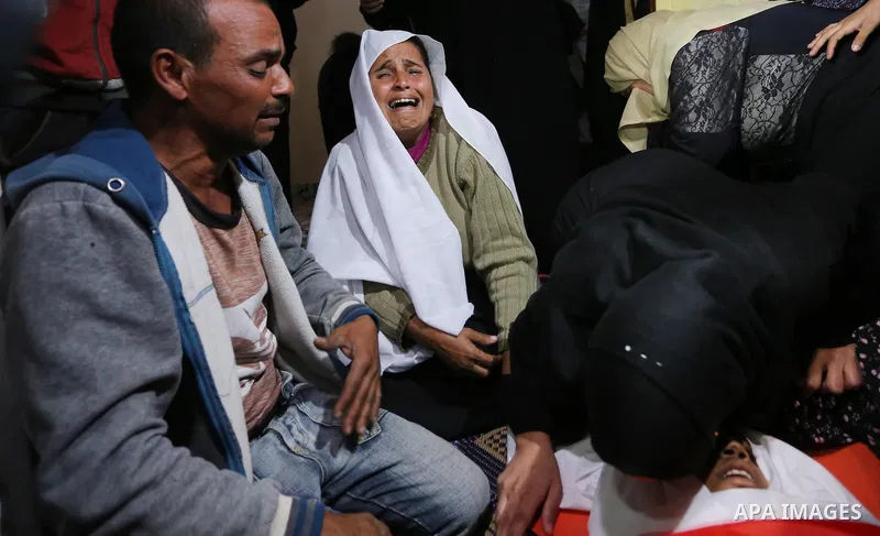 Relatives of Palestinian teenager Khaled Saed, who was killed in an Israeli air strike on the Gaza Strip , mourn over his body during his funeral in Deir el-Balah in central of the Gaza Strip on October 29, 2018. Photo b...