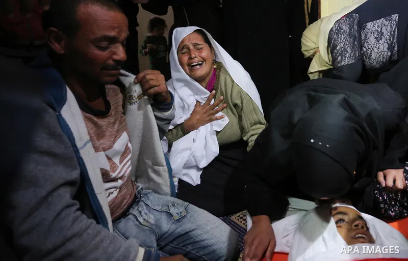 Relatives of Palestinian teenager Khaled Saed, who was killed in an Israeli air strike on the Gaza Strip , mourn over his body during his funeral in Deir el-Balah in central of the Gaza Strip on October 29, 2018. Photo b...