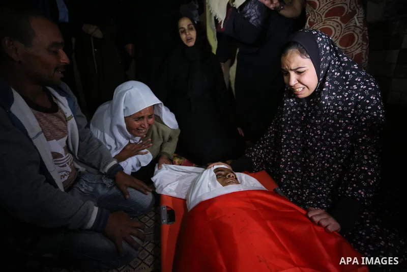 Relatives of Palestinian teenager Khaled Saed, who was killed in an Israeli air strike on the Gaza Strip , mourn over his body during his funeral in Deir el-Balah in central of the Gaza Strip on October 29, 2018. Photo b...