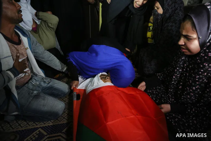 Relatives of Palestinian teenager Khaled Saed, who was killed in an Israeli air strike on the Gaza Strip , mourn over his body during his funeral in Deir el-Balah in central of the Gaza Strip on October 29, 2018. Photo b...