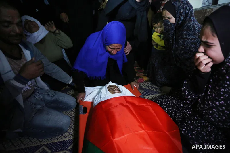 Relatives of Palestinian teenager Khaled Saed, who was killed in an Israeli air strike on the Gaza Strip , mourn over his body during his funeral in Deir el-Balah in central of the Gaza Strip on October 29, 2018. Photo b...