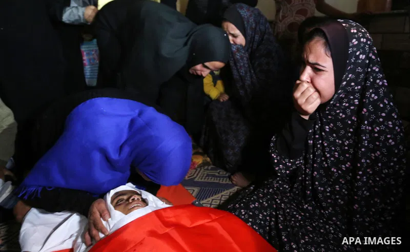 Relatives of Palestinian teenager Khaled Saed, who was killed in an Israeli air strike on the Gaza Strip , mourn over his body during his funeral in Deir el-Balah in central of the Gaza Strip on October 29, 2018. Photo b...