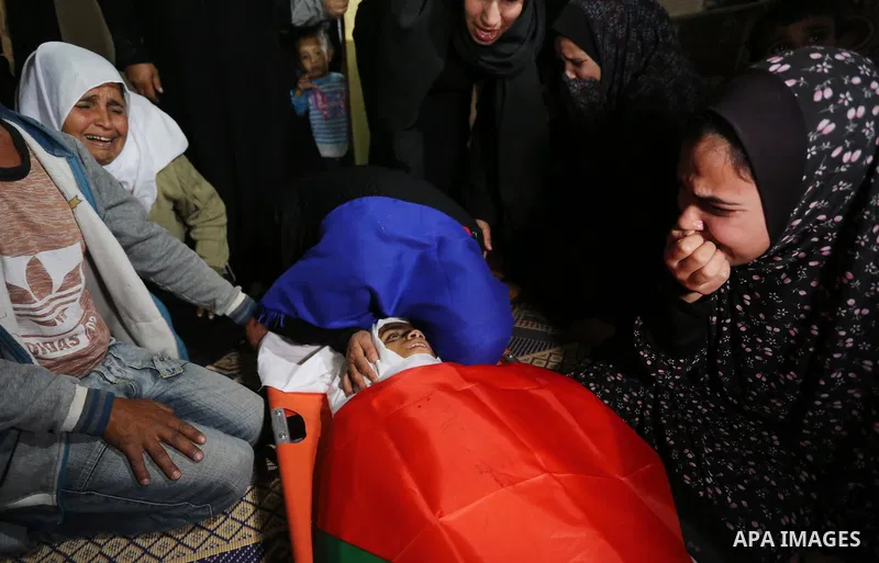 Relatives of Palestinian teenager Khaled Saed, who was killed in an Israeli air strike on the Gaza Strip , mourn over his body during his funeral in Deir el-Balah in central of the Gaza Strip on October 29, 2018. Photo b...