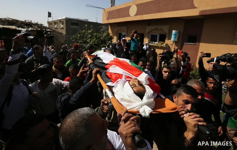 Palestinian mourners carry the bodies of three Palestinian teenagers who were killed in an Israeli air strike on the Gaza Strip during their funeral in Deir el-Balah in central of the Gaza Strip on October 29, 2018. Phot...