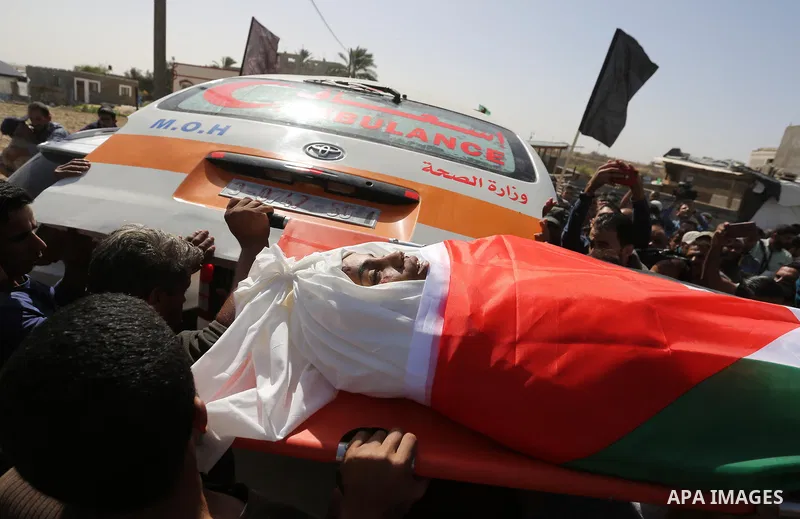 Palestinian mourners carry the bodies of three Palestinian teenagers who were killed in an Israeli air strike on the Gaza Strip during their funeral in Deir el-Balah in central of the Gaza Strip on October 29, 2018. Phot...