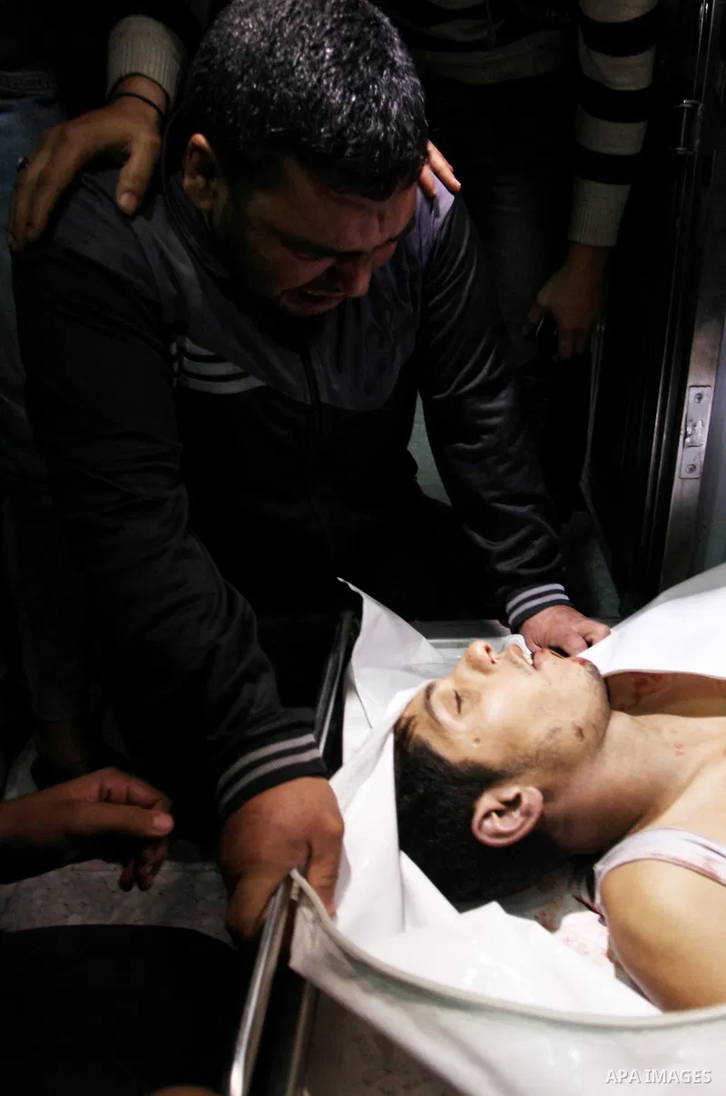 Relatives of Palestinian Mohammed abu Abada, 27, who was shot dead by Israeli forces during clashes along the Gaza sea barrier on the maritime border with Israel, in the northern Gaza Strip, mourn over his body at morgue...