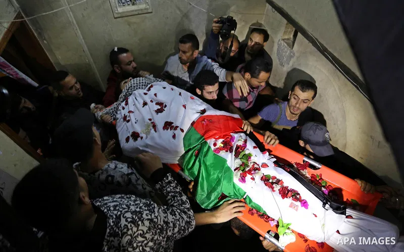 Mourners carry the body of Palestinian Mohammed abu Abada, 27, who was shot dead by Israeli forces during a demonstration against the Israeli blockade on Gaza Strip, along the Gaza sea barrier on the maritime border with...