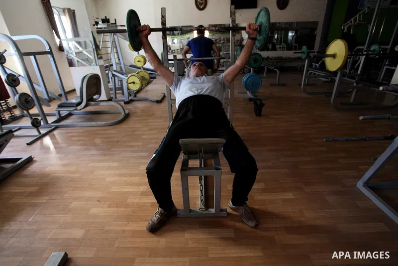 Palestinian coach Ali al-Nono, 74, practices weightlifting, at a club in Gaza City on November 3, 2018. Al-Nono playing weightlifting for more than 50 years and won in prizes in local and Arab competitions. Photo by Mahm...