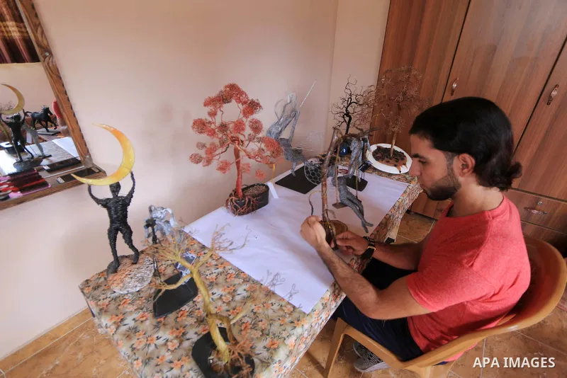 Palestinian artist Mahmoud Nabaheen, 20, uses wires to make a handmade statues, shapes and figures, at his home in al-Bureij in the center of Gaza Strip on November 5, 2018. Photo by Mahmoud Khattab