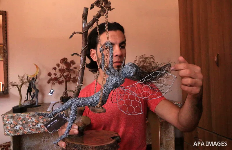 Palestinian artist Mahmoud Nabaheen, 20, uses wires to make a handmade statues, shapes and figures, at his home in al-Bureij in the center of Gaza Strip on November 5, 2018. Photo by Mahmoud Khattab