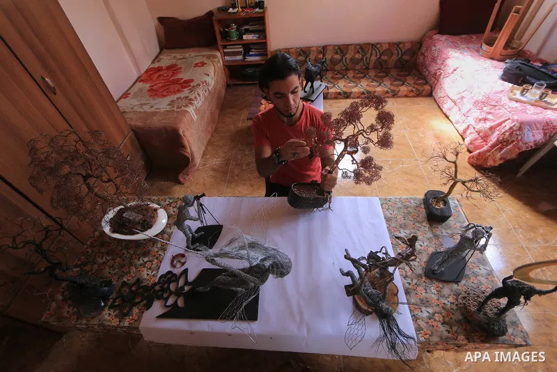 Palestinian artist Mahmoud Nabaheen, 20, uses wires to make a handmade statues, shapes and figures, at his home in al-Bureij in the center of Gaza Strip on November 5, 2018. Photo by Mahmoud Khattab