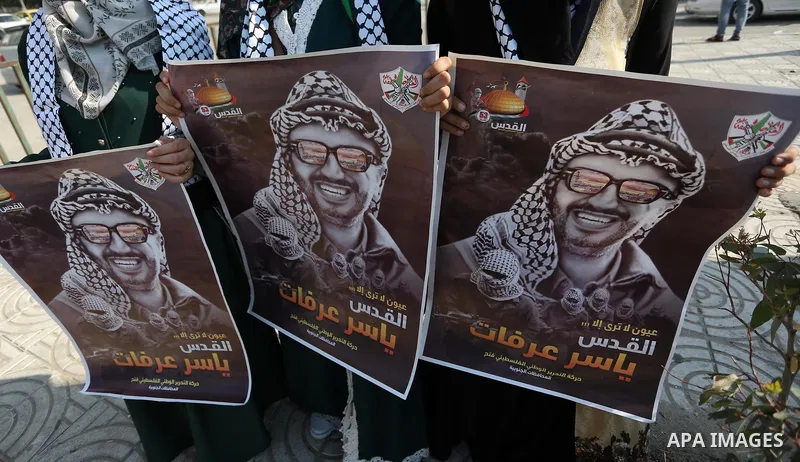 Palestinians hold posters depicting late Palestinian leader Yasser Arafat to mark the 14th anniversary of his death in Gaza City on November 11, 2018. Photo by Ashraf Amra