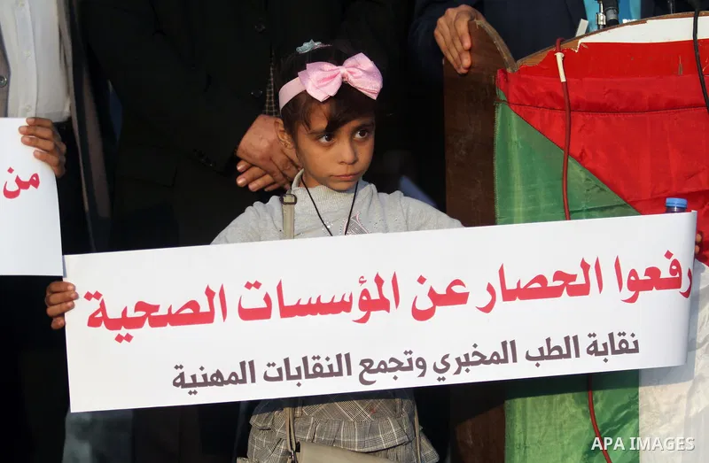 Palestinian children hold posters during a protest against Israeli blockade at the seaport in Gaza city on November 11, 2018. Photo by Mahmoud Ajjour