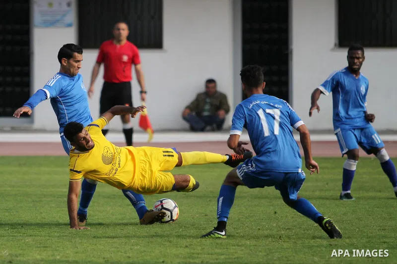 Palestinian players of Khadamat al-Shati (in blue) and players of Ahly Beit Hanoun in (yellow), compete during a a football match at Yarmouk Stadium in Gaza City on November 11, 2018. Photo by Mahmoud Ajjour