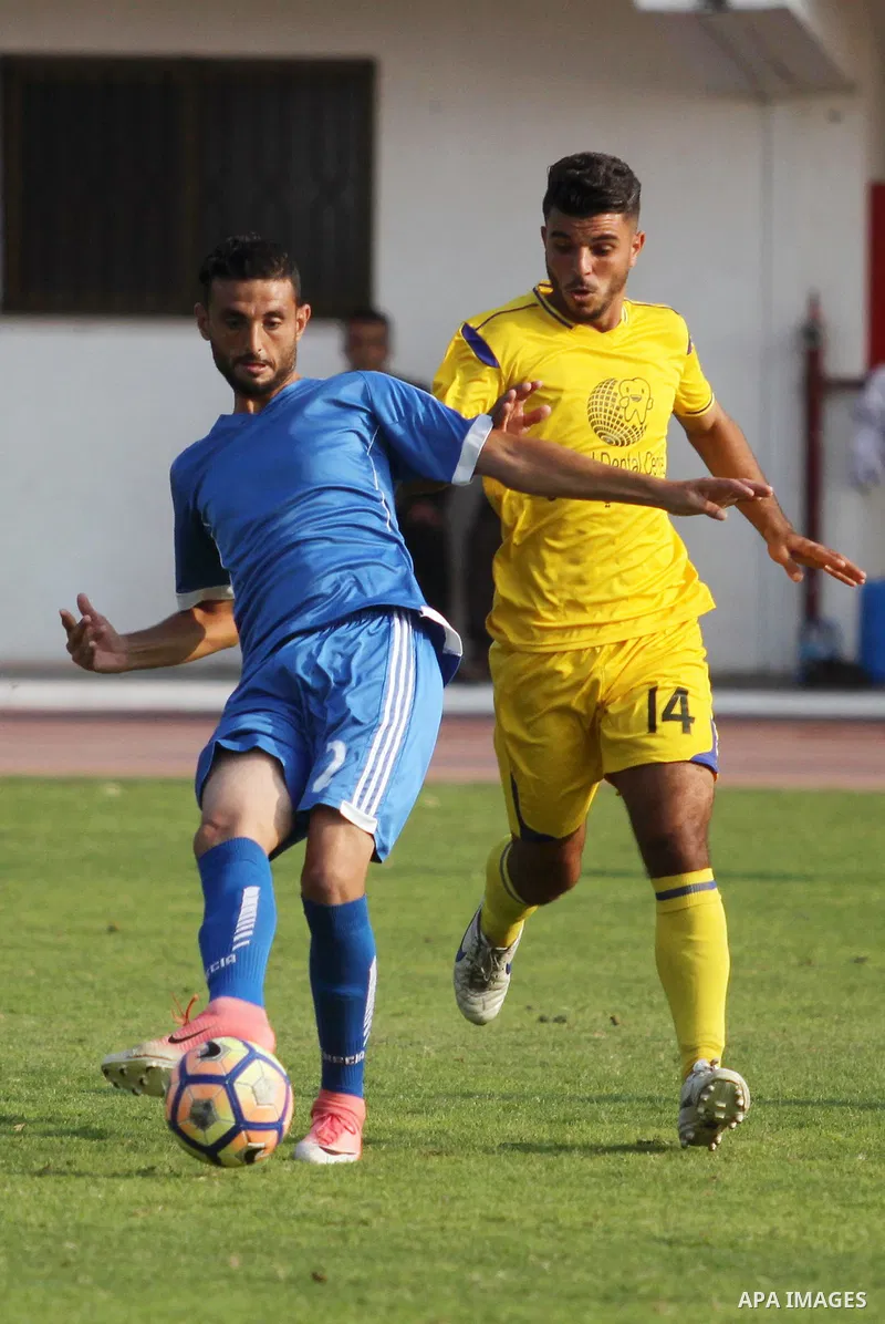 Palestinian players of Khadamat al-Shati (in blue) and players of Ahly Beit Hanoun in (yellow), compete during a a football match at Yarmouk Stadium in Gaza City on November 11, 2018. Photo by Mahmoud Ajjour