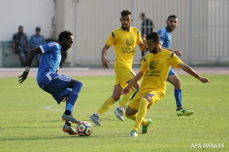 Palestinian players of Khadamat al-Shati (in blue) and players of Ahly Beit Hanoun in (yellow), compete during a a football match at Yarmouk Stadium in Gaza City on November 11, 2018. Photo by Mahmoud Ajjour