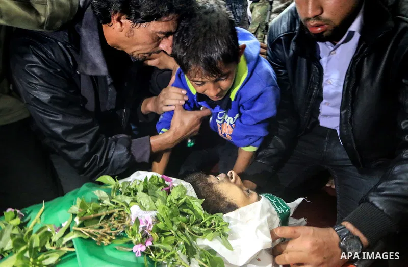 Relatives of Mustafa Abu Odeh and Mahmoud Atallah, two of the seven Palestinians killed during an Israeli special forces operation in the Gaza Strip, morun over their bodies during their funeral, in Khan Younis in the so...