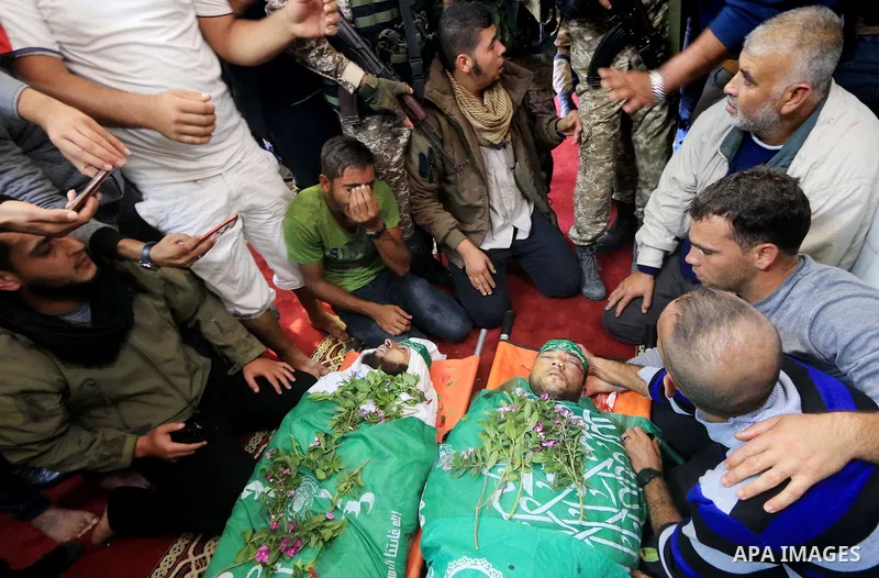 Relatives of Mustafa Abu Odeh and Mahmoud Atallah, two of the seven Palestinians killed during an Israeli special forces operation in the Gaza Strip, morun over their bodies during their funeral, in Khan Younis in the so...