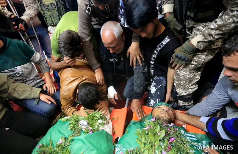 Relatives of Mustafa Abu Odeh and Mahmoud Atallah, two of the seven Palestinians killed during an Israeli special forces operation in the Gaza Strip, morun over their bodies during their funeral, in Khan Younis in the so...