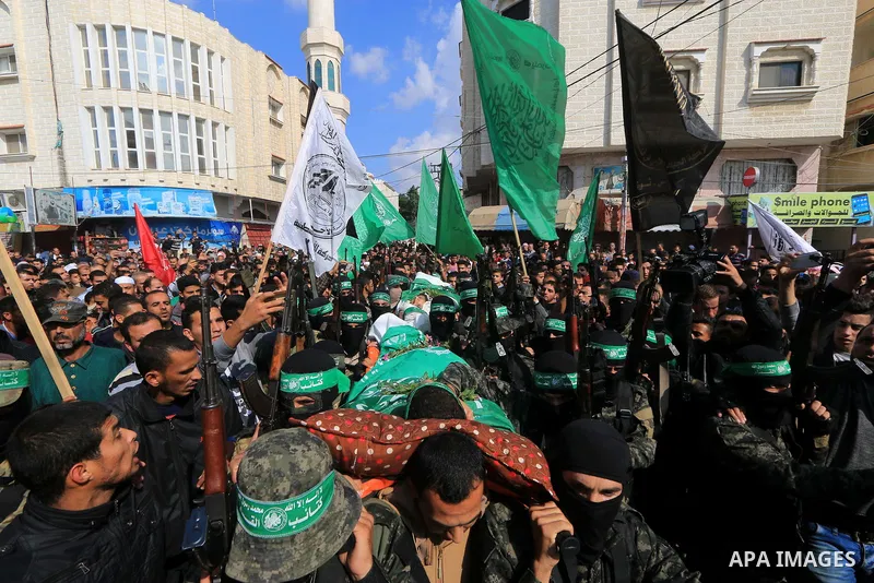 Palestinian militants of the Islamist movement Hamas' military wing Al-Qassam Brigades, carry bodies of Mustafa Abu Odeh and Mahmoud Atallah, two of the seven Palestinians killed during an Israeli special forces operatio...