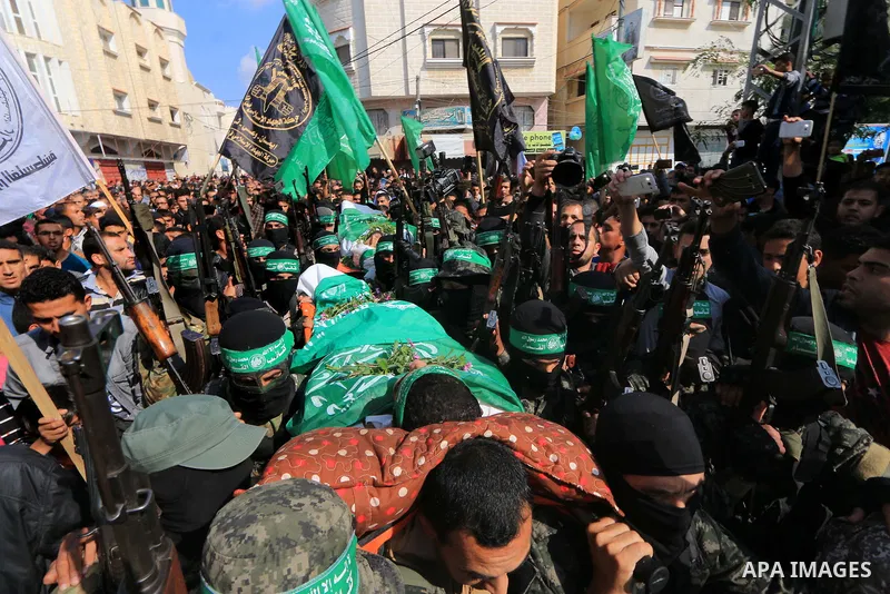 Palestinian militants of the Islamist movement Hamas' military wing Al-Qassam Brigades, carry bodies of Mustafa Abu Odeh and Mahmoud Atallah, two of the seven Palestinians killed during an Israeli special forces operatio...