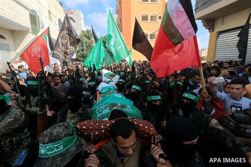 Palestinian militants of the Islamist movement Hamas' military wing Al-Qassam Brigades, carry bodies of Mustafa Abu Odeh and Mahmoud Atallah, two of the seven Palestinians killed during an Israeli special forces operatio...