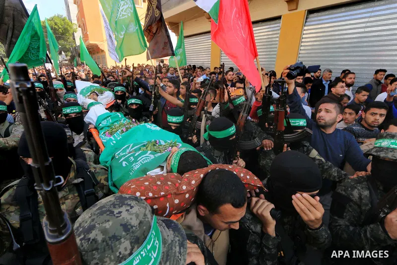 Palestinian militants of the Islamist movement Hamas' military wing Al-Qassam Brigades, carry bodies of Mustafa Abu Odeh and Mahmoud Atallah, two of the seven Palestinians killed during an Israeli special forces operatio...