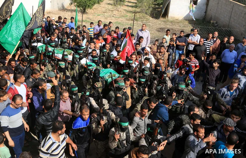 Palestinian militants of the Islamist movement Hamas' military wing Al-Qassam Brigades, carry bodies of Mustafa Abu Odeh and Mahmoud Atallah, two of the seven Palestinians killed during an Israeli special forces operatio...