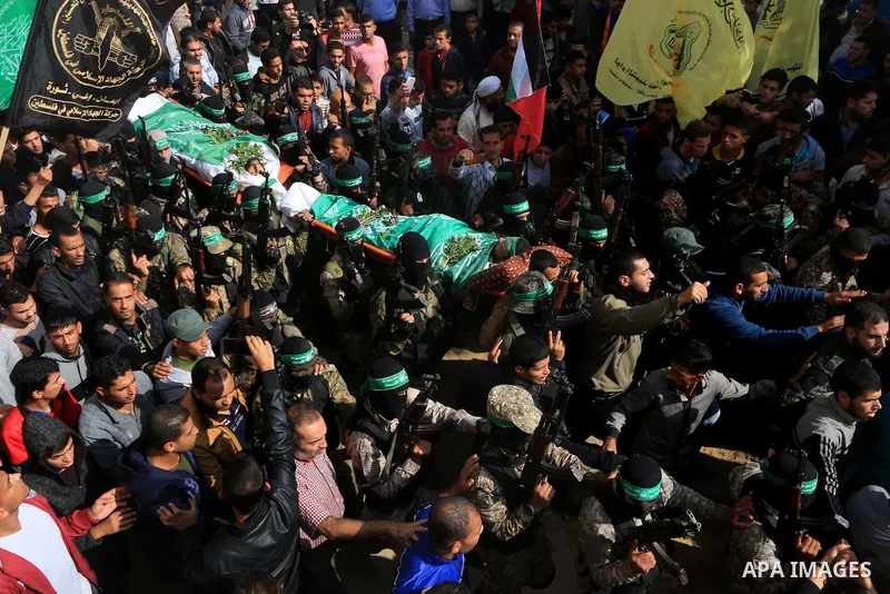 Palestinian militants of the Islamist movement Hamas' military wing Al-Qassam Brigades, carry bodies of Mustafa Abu Odeh and Mahmoud Atallah, two of the seven Palestinians killed during an Israeli special forces operatio...