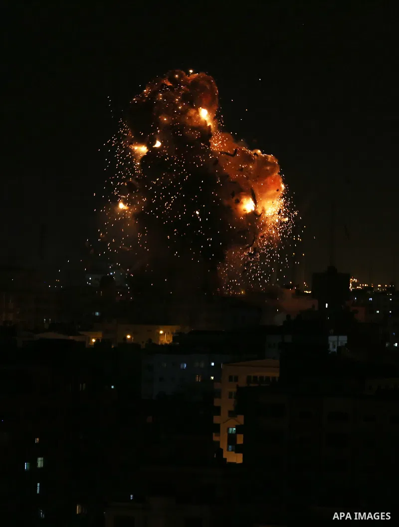 A picture taken on November 12, 2018, shows a ball of fire and smoke rise above the building housing the television station al-Aqsa TV during an Israeli air strike in Gaza City. Israel's military said it was carrying out...