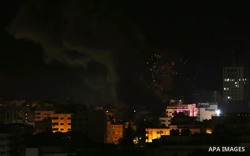 A picture taken on November 12, 2018, shows a ball of fire and smoke rise above the building housing the television station al-Aqsa TV during an Israeli air strike in Gaza City. Israel's military said it was carrying out...