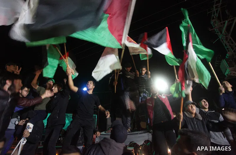 Palestinians shout slogans and hold national flags as they celebrate during a rally, in Gaza City on November 13, 2018. Photo by Mahmoud Ajjour