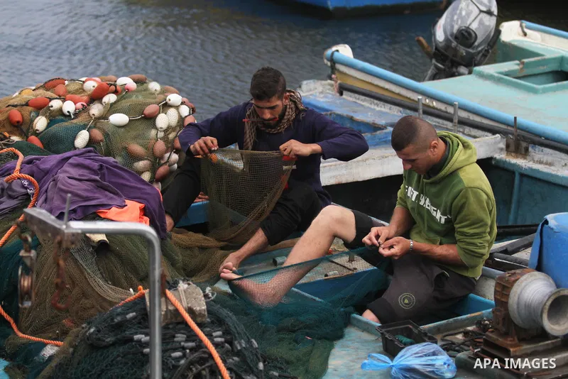 Palestinian fishermen work on their fishing boats in the sea at the seaport in Gaza city on November 15, 2018. The Israeli navy allowed Palestinian fishermen, on Thursday, to conduct their work within six nautical miles...