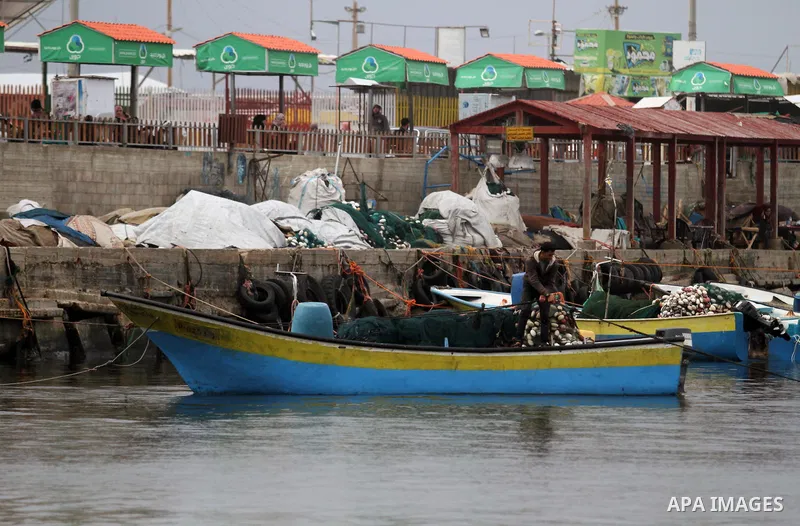 Palestinian fishermen work on their fishing boats in the sea at the seaport in Gaza city on November 15, 2018. The Israeli navy allowed Palestinian fishermen, on Thursday, to conduct their work within six nautical miles...
