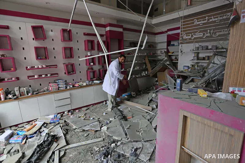 A Palestinian Doctor inspects the rubble of pharmacy destroyed by Israeli air strikes in Gaza City on November 15, 2018. Photo by Ashraf Amra