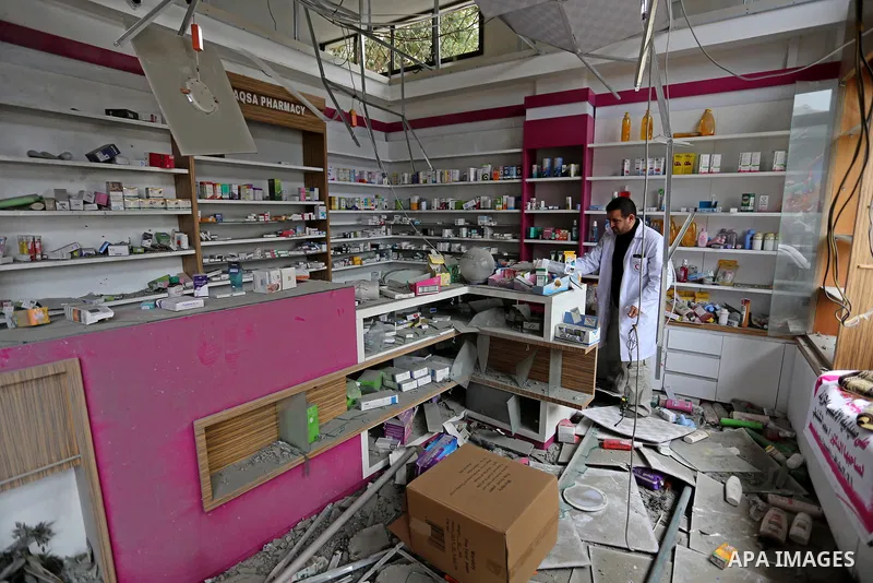 A Palestinian Doctor inspects the rubble of pharmacy destroyed by Israeli air strikes in Gaza City on November 15, 2018. Photo by Ashraf Amra