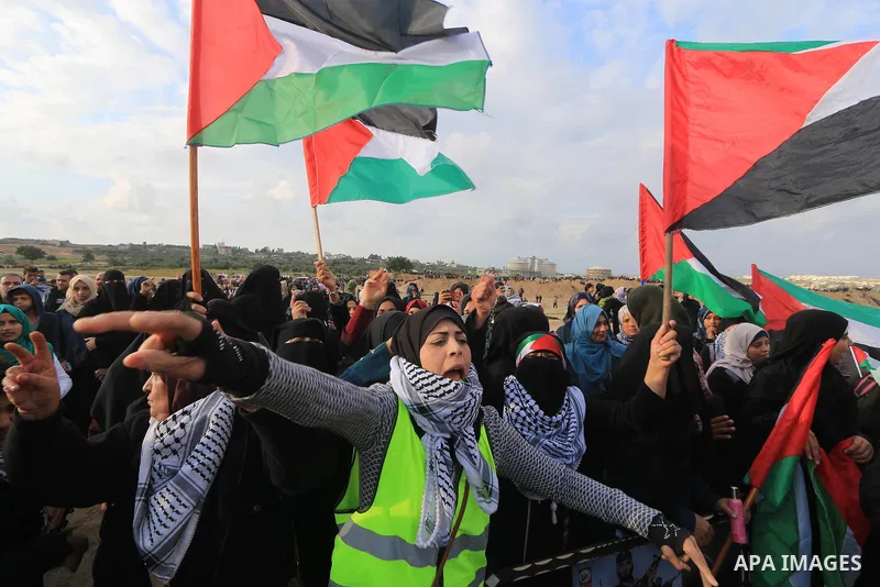 Palestinian protesters gather during clashes with Israeli troops in tents protest where Palestinians demand the right to return to their homeland at the Israel-Gaza border, in al-Bureij in the center of Gaza Strip on Nov...