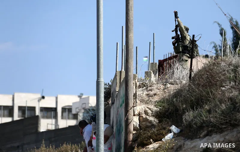 Israeli forces take position during clashes with Palestinian protesters after prevent Palestinian farmers to reach to their lands and planting olive trees, in the West Bank village of Urif, near Nablus on November 17, 20...
