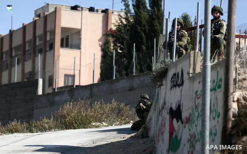 Israeli forces take position during clashes with Palestinian protesters after prevent Palestinian farmers to reach to their lands and planting olive trees, in the West Bank village of Urif, near Nablus on November 17, 20...
