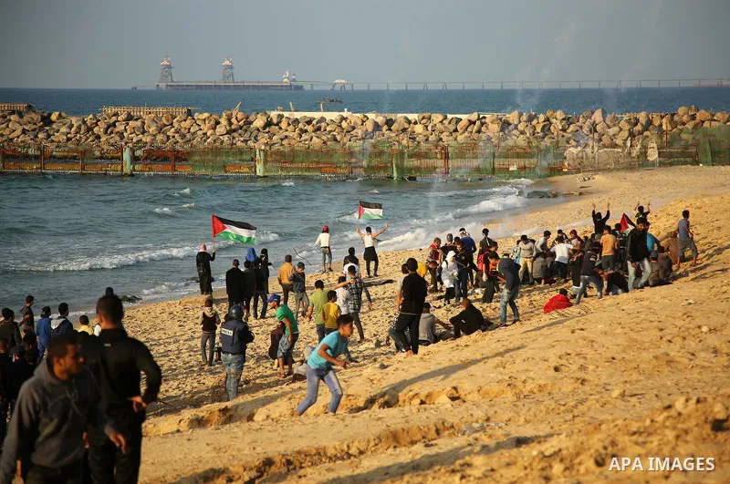 Palestinian protesters gather during clashes with Israeli forces in a demonstration against the Israeli blockade on Gaza Strip, along the Gaza sea barrier on the maritime border with Israel near Kibbutz Zikim, north of B...