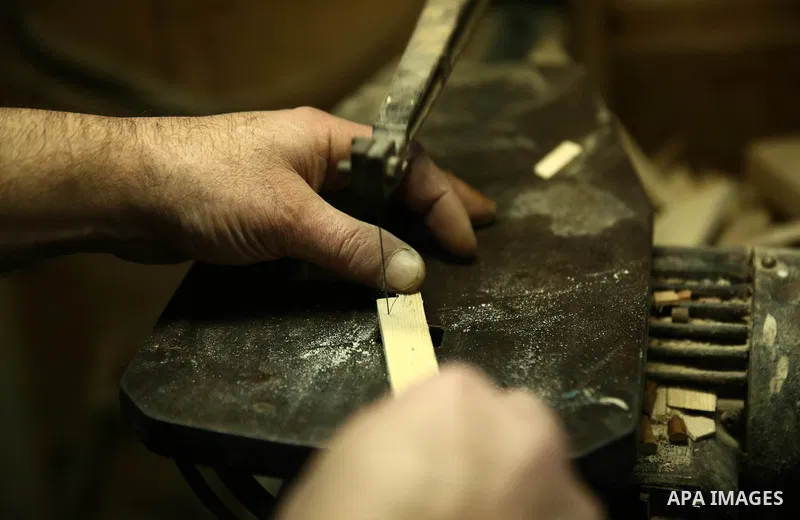 Palestinian nurse, Ali Hassanin, 57, who makes lutes, known in Arabic as an "Oud", works on a musical instrument, at his workshop, in the West Bank city of Nablus on November 26, 2018. Photo by Shadi Jarar'ah