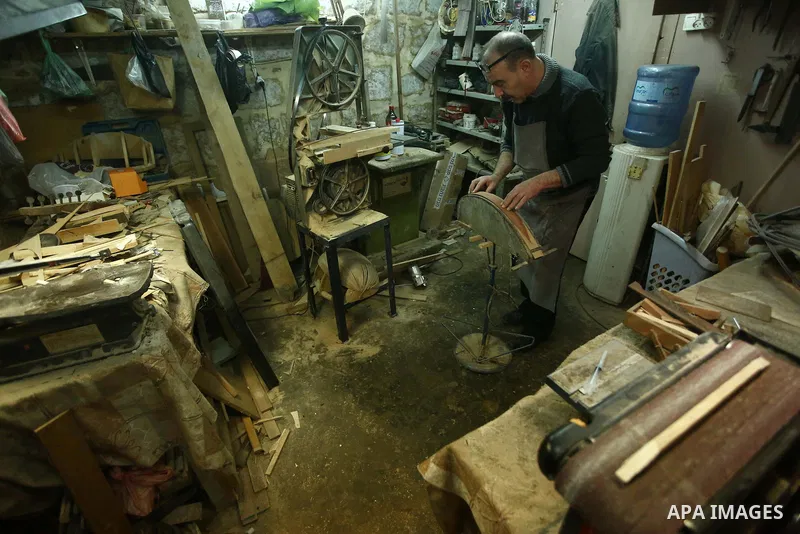 Palestinian nurse, Ali Hassanin, 57, who makes lutes, known in Arabic as an "Oud", works on a musical instrument, at his workshop, in the West Bank city of Nablus on November 26, 2018. Photo by Shadi Jarar'ah