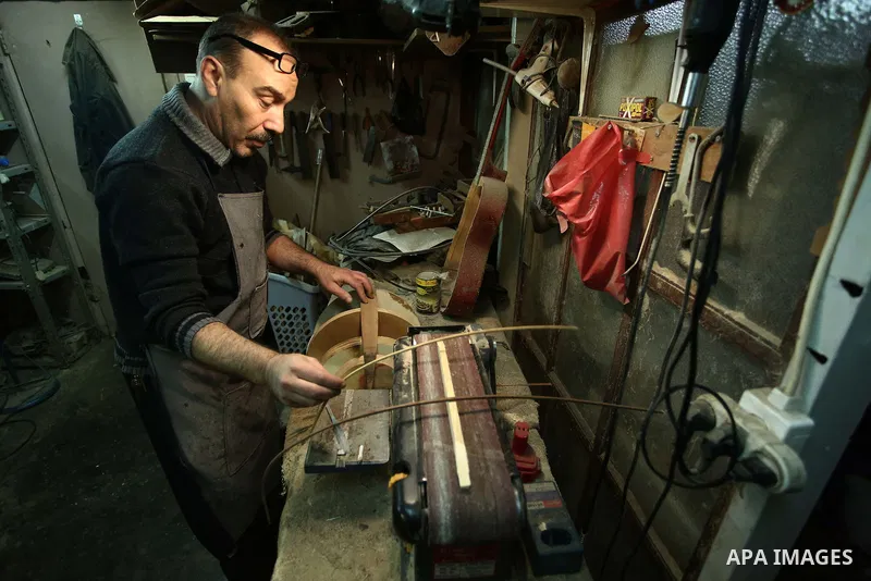 Palestinian nurse, Ali Hassanin, 57, who makes lutes, known in Arabic as an "Oud", works on a musical instrument, at his workshop, in the West Bank city of Nablus on November 26, 2018. Photo by Shadi Jarar'ah