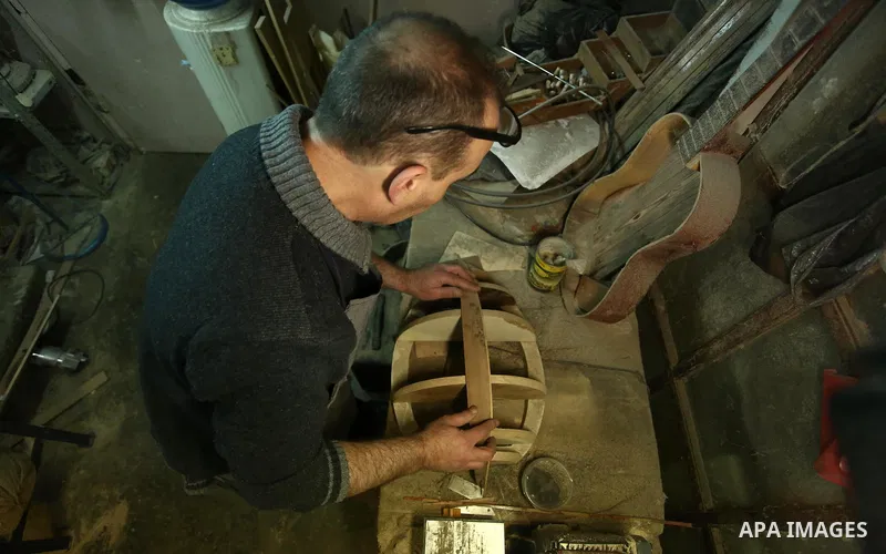 Palestinian nurse, Ali Hassanin, 57, who makes lutes, known in Arabic as an "Oud", works on a musical instrument, at his workshop, in the West Bank city of Nablus on November 26, 2018. Photo by Shadi Jarar'ah