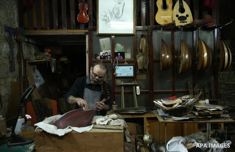Palestinian nurse, Ali Hassanin, 57, who makes lutes, known in Arabic as an "Oud", works on a musical instrument, at his workshop, in the West Bank city of Nablus on November 26, 2018. Photo by Shadi Jarar'ah