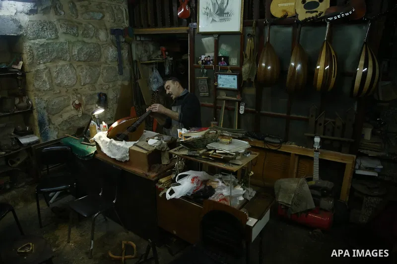 Palestinian nurse, Ali Hassanin, 57, who makes lutes, known in Arabic as an "Oud", works on a musical instrument, at his workshop, in the West Bank city of Nablus on November 26, 2018. Photo by Shadi Jarar'ah