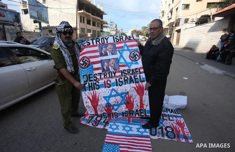 Palestinians burn an Israeli, British and U.S. flags during a protest to show solidarity with Palestinian prisoners held in Israeli jails, in front of Red cross office in Gaza city, on November, 26, 2018. Photo by Mahmou...