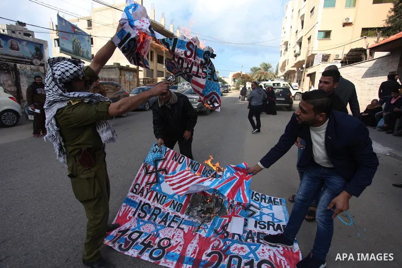 Palestinians burn an Israeli, British and U.S. flags during a protest to show solidarity with Palestinian prisoners held in Israeli jails, in front of Red cross office in Gaza city, on November, 26, 2018. Photo by Mahmou...