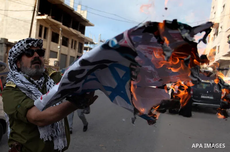 Palestinians burn an Israeli, British and U.S. flags during a protest to show solidarity with Palestinian prisoners held in Israeli jails, in front of Red cross office in Gaza city, on November, 26, 2018. Photo by Mahmou...