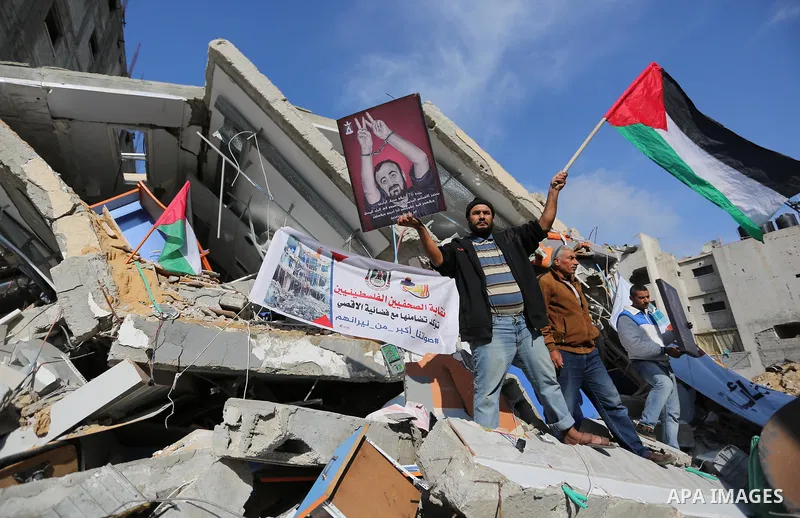 Palestinians take part during a protest against targeting of the television station al-Aqsa TV which was destroyed by Israeli air strikes in Gaza City on November 26, 2018. Photo by Ashraf Amra